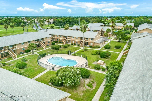 an aerial view of a house with a garden and lake view