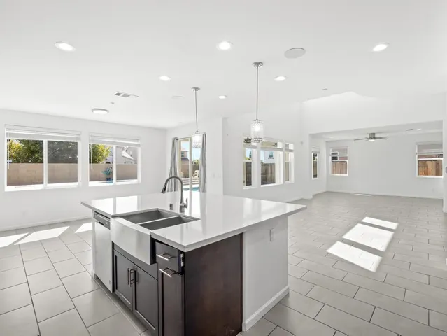 a kitchen with stainless steel appliances granite countertop a sink and a stove top oven with wooden floor