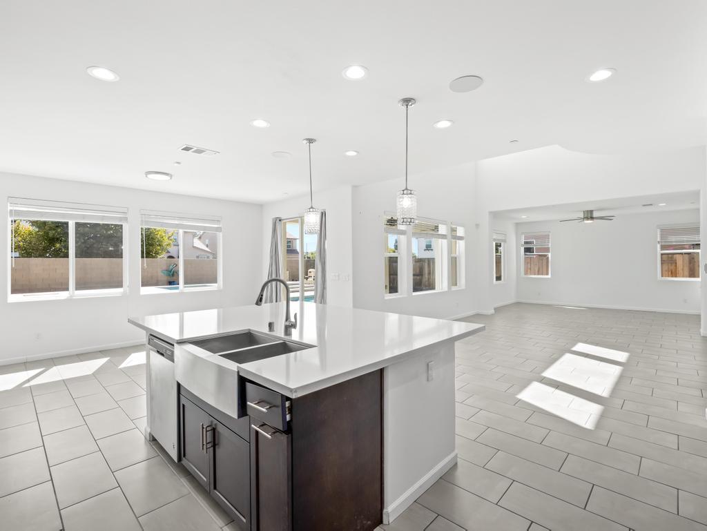 3438 Lincoln Avenue Clovis, CA 93619 - Photo 11 of 52 a kitchen with stainless steel appliances granite countertop a sink and a stove top oven with wooden floor