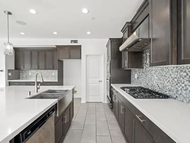 a kitchen with stainless steel appliances a sink stove and cabinets