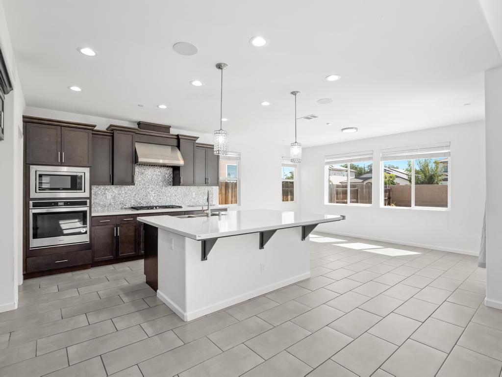 3438 Lincoln Avenue Clovis, CA 93619 - Photo 13 of 52 a large white kitchen with a stove a sink a microwave and a refrigerator