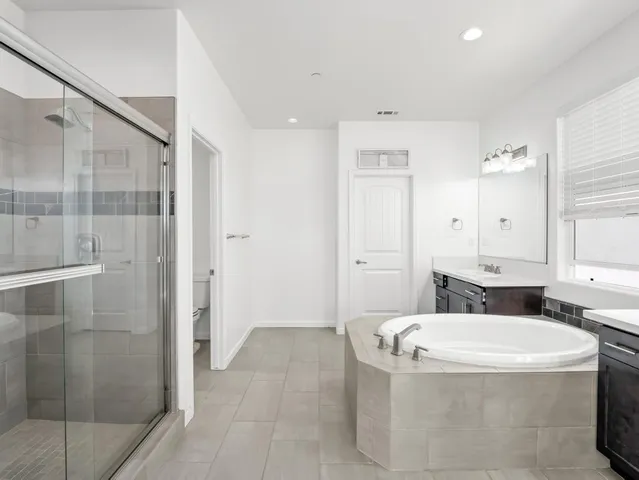 an empty room with a window and a ceiling fan