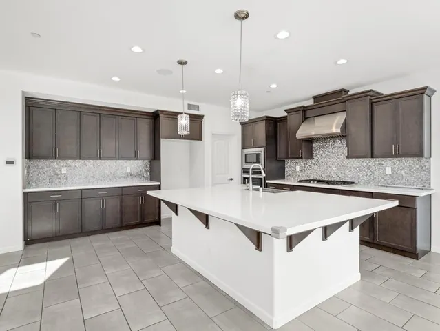 a large kitchen with kitchen island a sink stainless steel appliances and cabinets