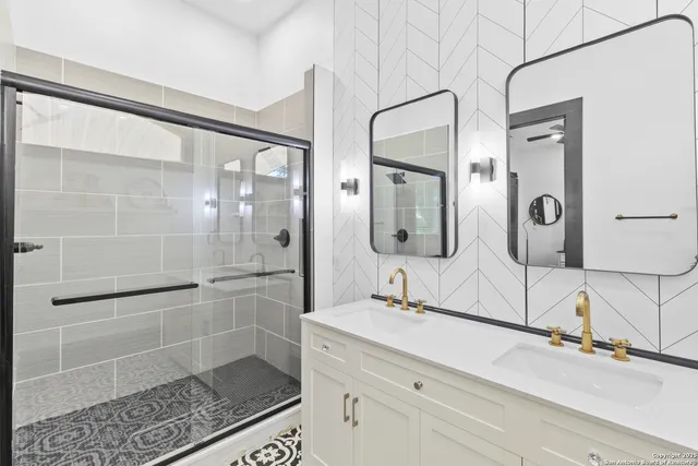 a bathroom with a double vanity sink mirror and shower