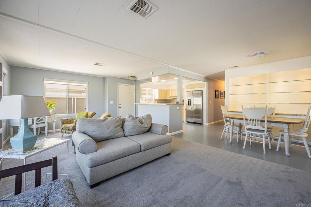 4650 Dulin Road, Unit 42 Fallbrook, CA 92003 - Photo 13 of 45 a living room with furniture a dining table and chairs with wooden floor