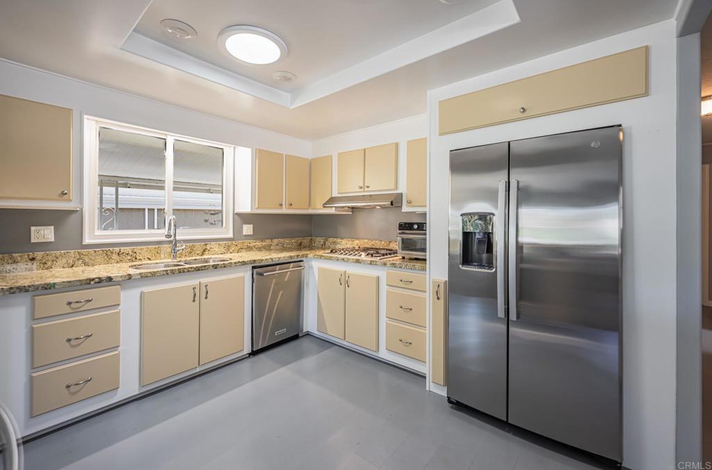 4650 Dulin Road, Unit 42 Fallbrook, CA 92003 - Photo 17 of 45 a kitchen with granite countertop a refrigerator sink and cabinets