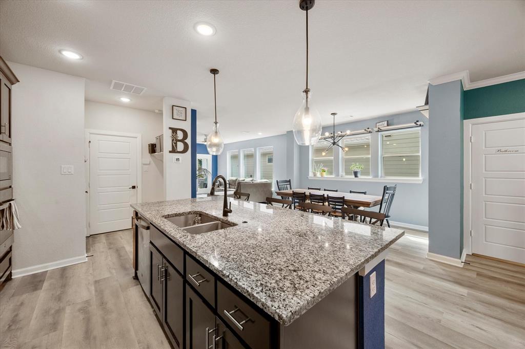 9224 Lamar Street Rowlett, TX 75089 - Photo 5 of 27 Kitchen island featuring a granite countertop, undermount stainless steel sink, and matte black faucet