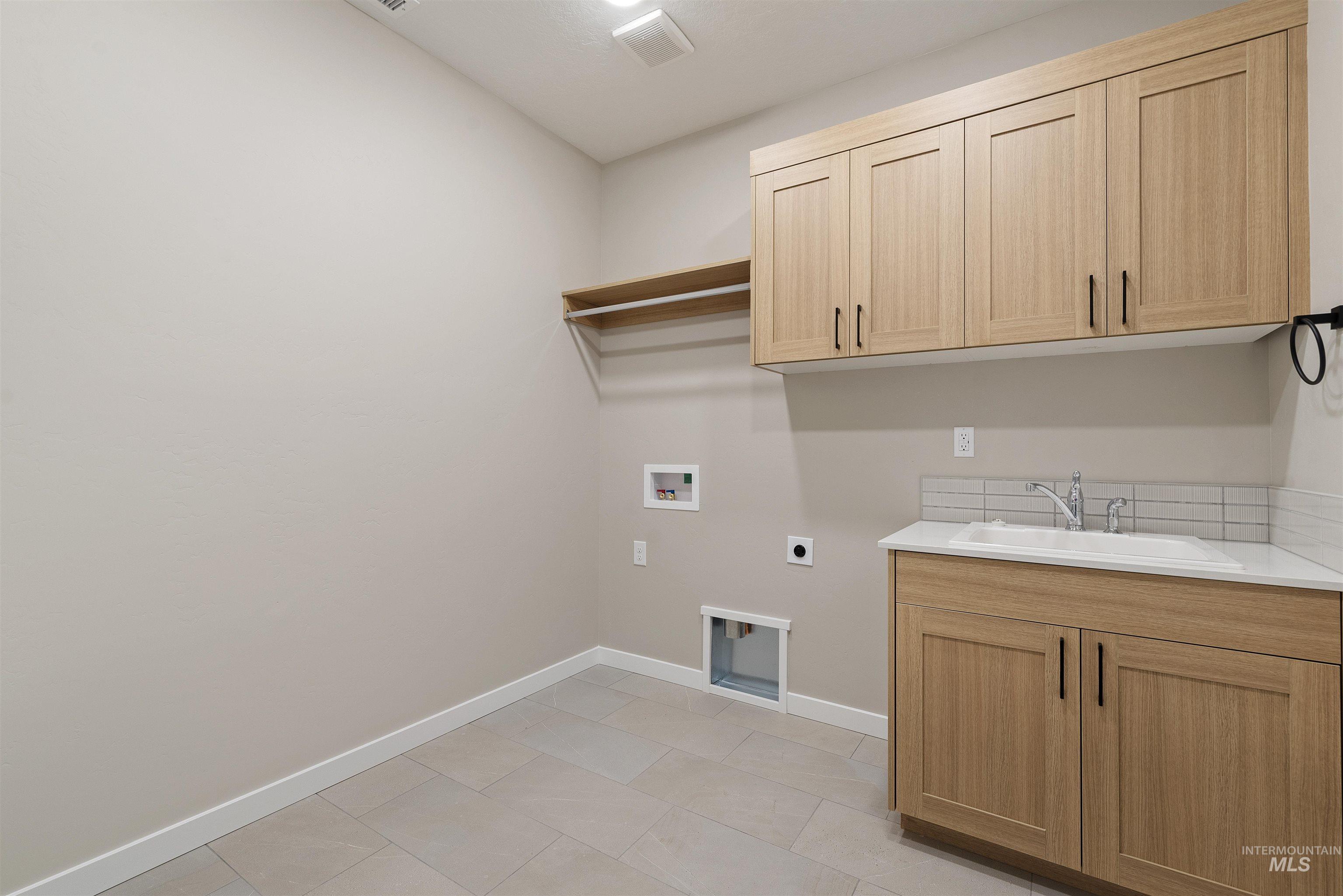 1935 West Bittern Street Nampa, ID 83686 - Photo 12 of 29 Laundry area featuring electric dryer hookup, hookup for a washing machine, cabinet space, and light tile patterned floors