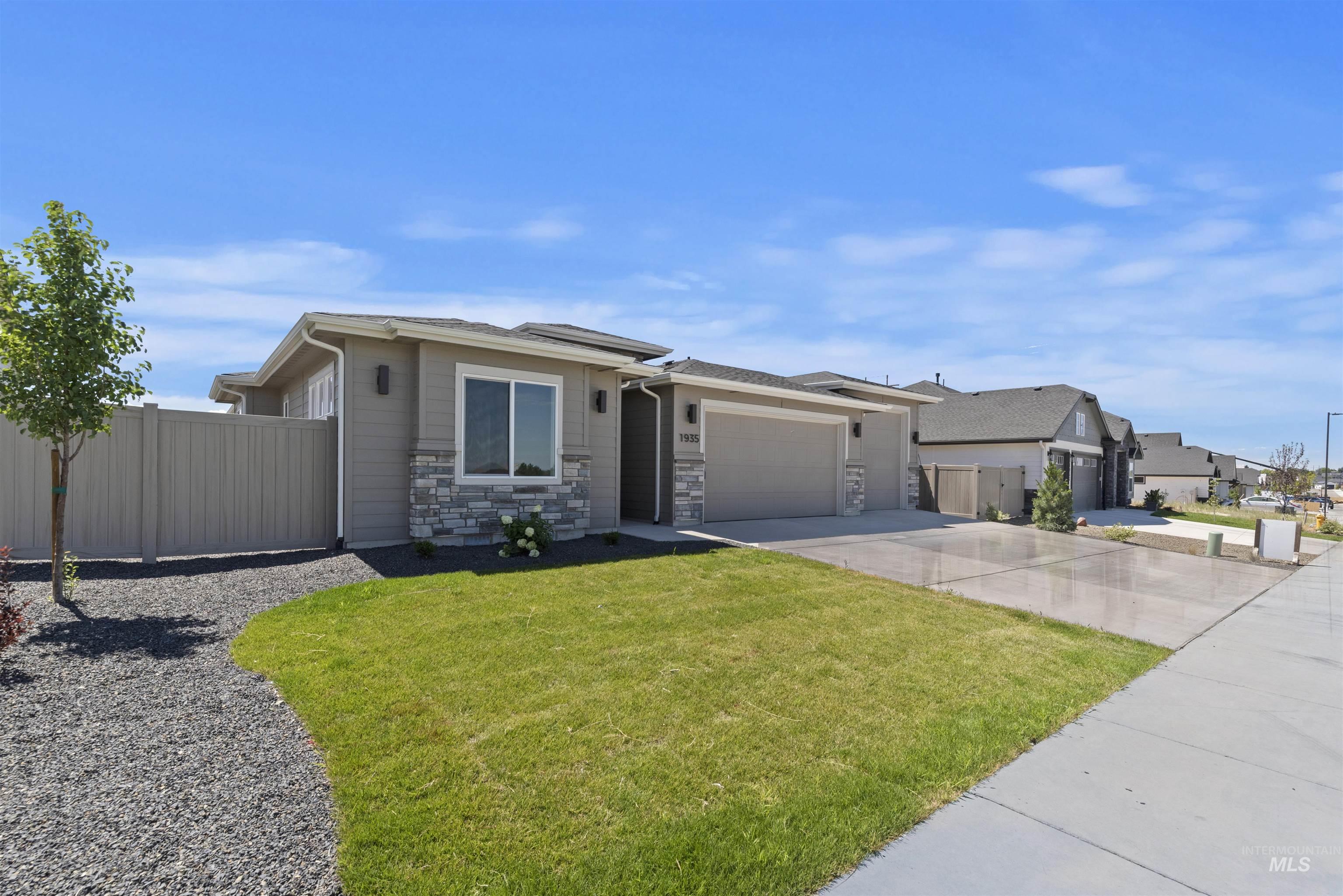 1935 West Bittern Street Nampa, ID 83686 - Photo 2 of 29 Prairie-style home with driveway, a garage, stone siding, and a residential view