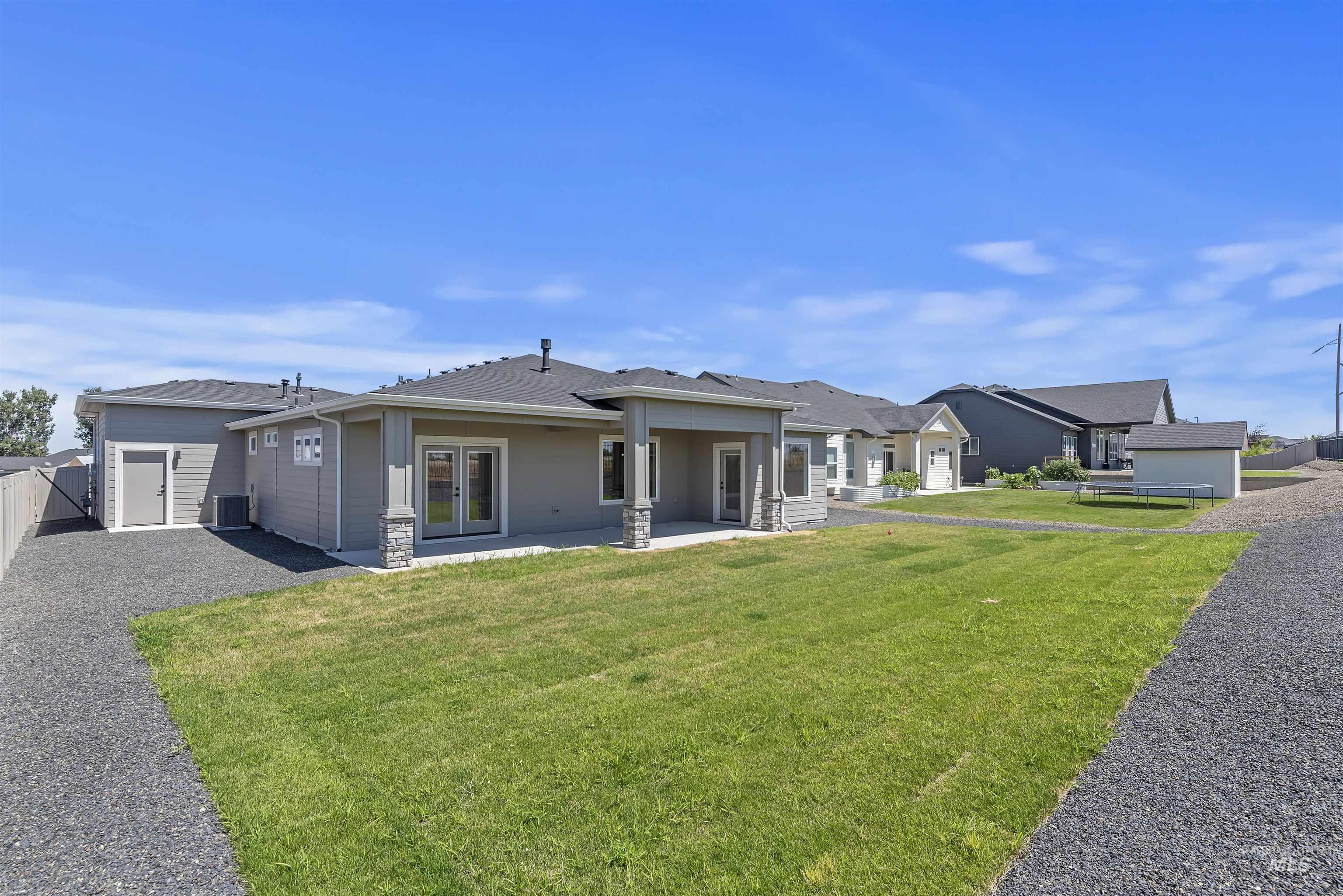 1935 West Bittern Street Nampa, ID 83686 - Photo 25 of 29 Rear view of house with french doors, stone siding, a patio area, a residential view, and roof with shingles