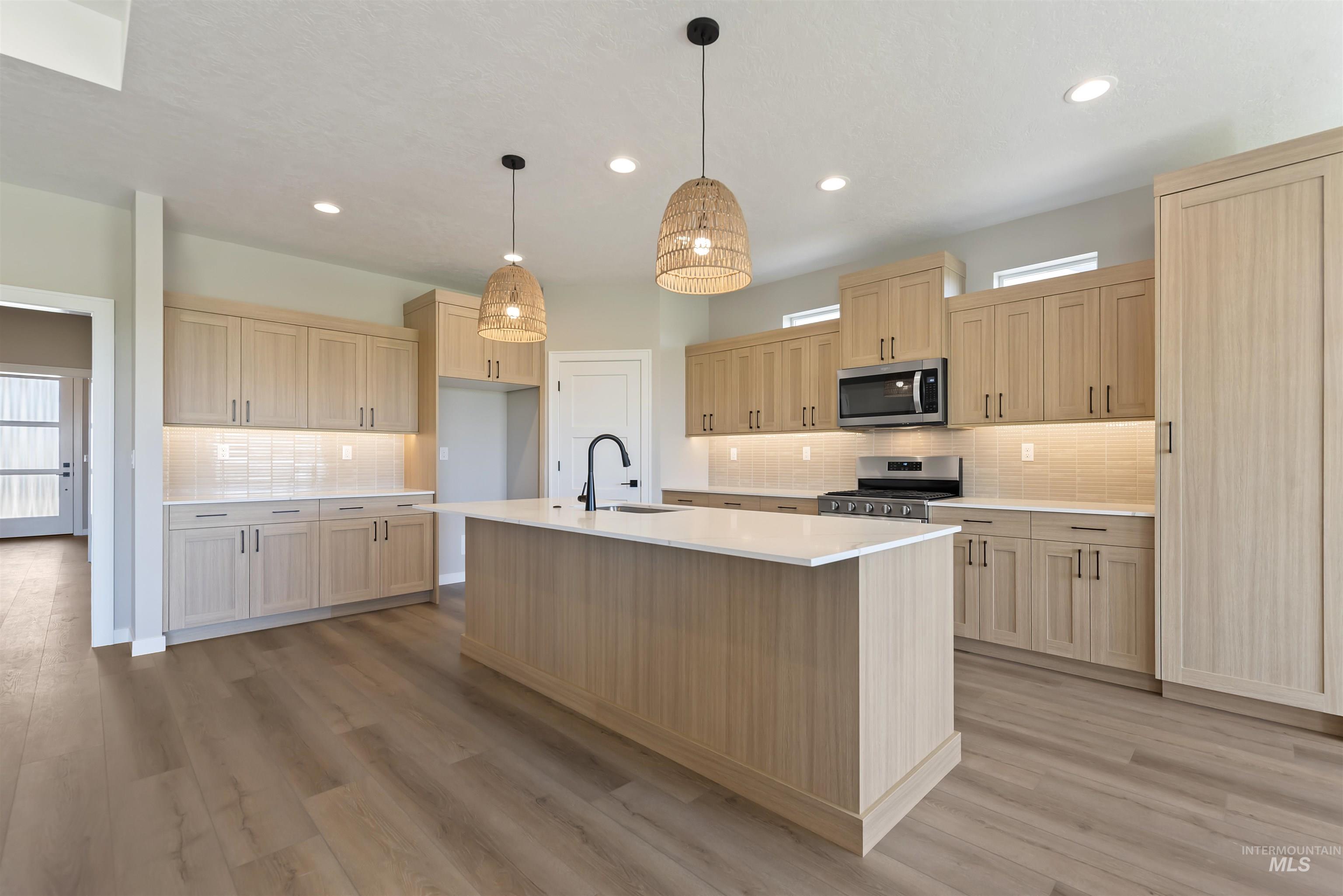 1935 West Bittern Street Nampa, ID 83686 - Photo 9 of 29 Kitchen featuring backsplash, stainless steel appliances, light brown cabinets, light countertops, and light wood-type flooring