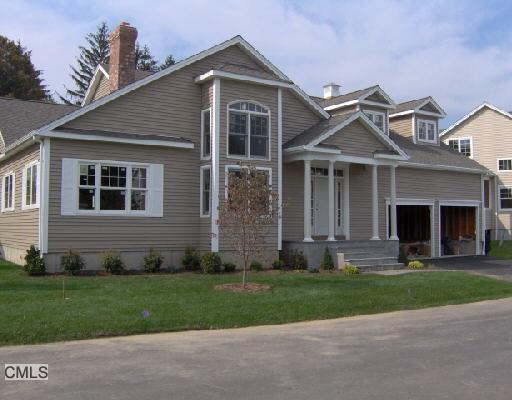 a front view of a house with a yard and trees