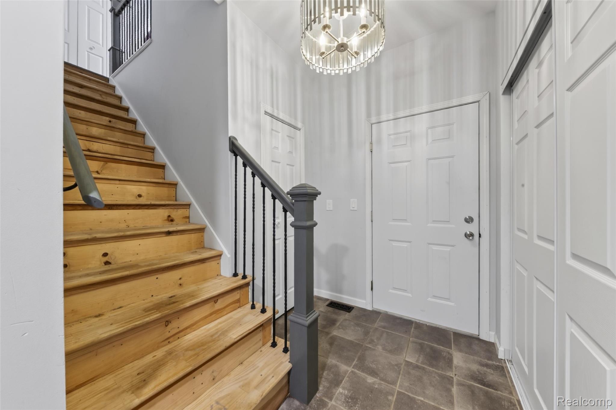 7447 Ore Lake Road Brighton, MI 48116 - Photo 16 of 45 Entry foyer featuring tile flooring, white panel doors, and a decorative chandelier
