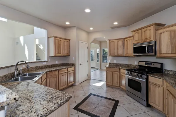 a kitchen with granite countertop white cabinets and black appliances