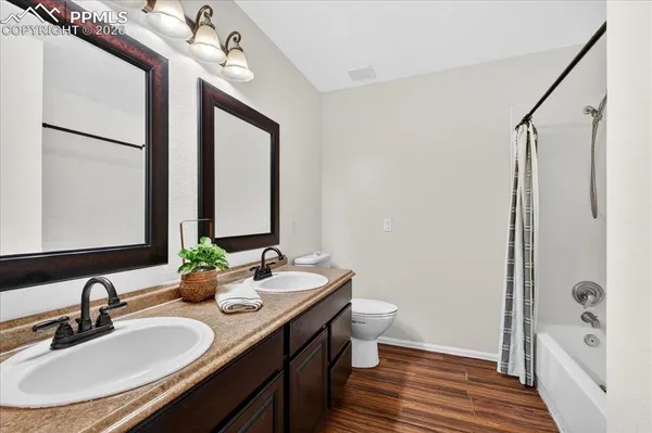a bathroom with a double vanity sink a mirror and a bathtub