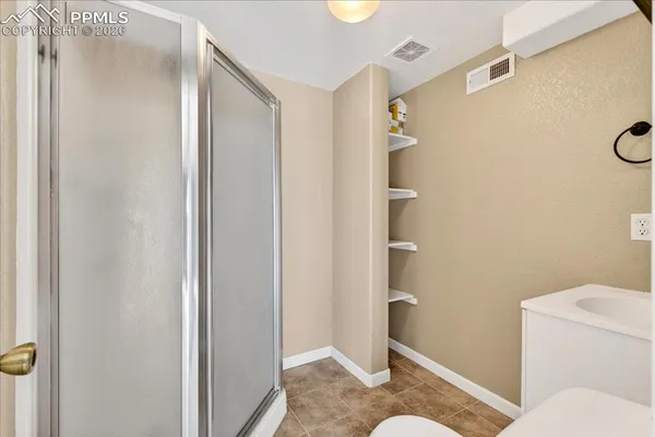 a bathroom with a granite countertop shower and a toilet