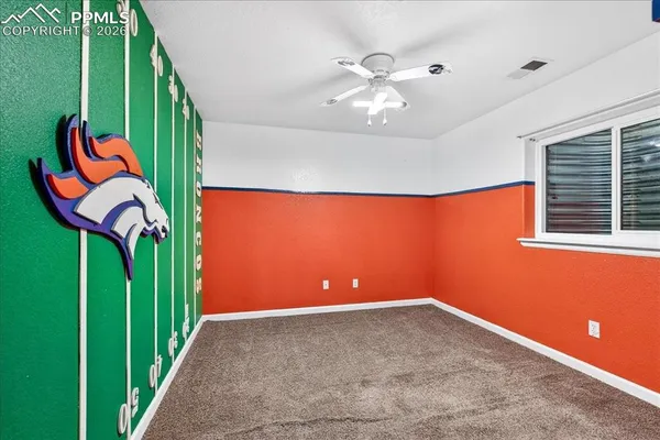 an empty room with a fan and window