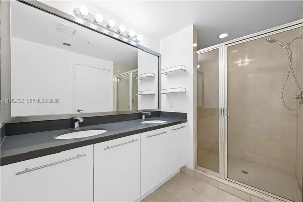 a bathroom with a granite countertop sink a mirror and a shower