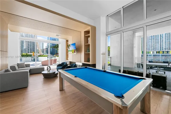 a room with furniture pool table and windows