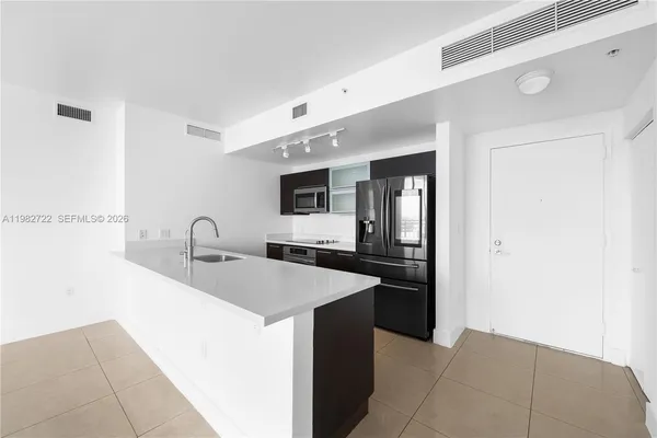 a kitchen with stainless steel appliances a sink and a refrigerator