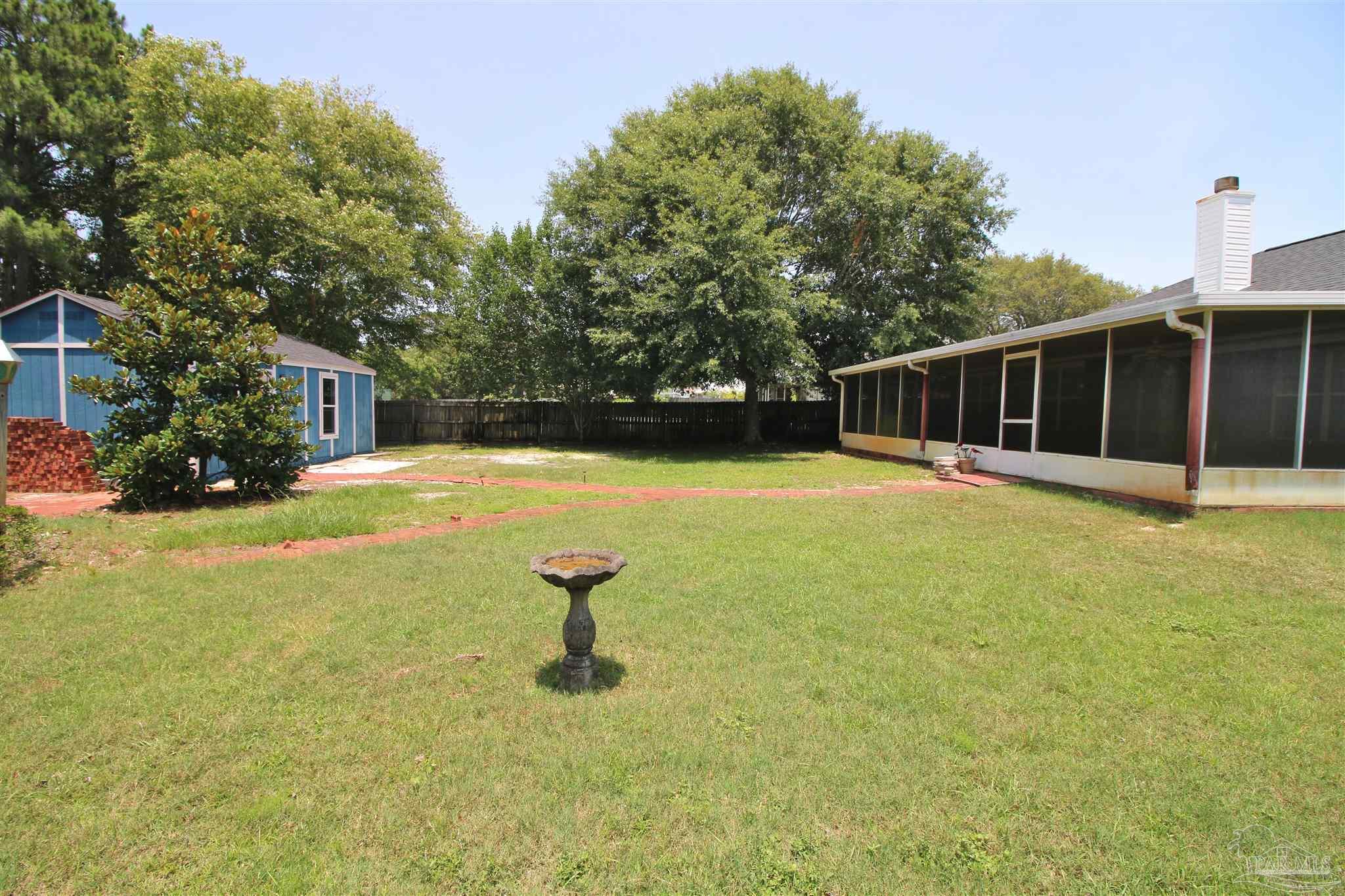 1701 Lighthouse Pointe Drive Gulf Breeze, FL 32563 - Photo 21 of 48 a swimming pool with some trees in the background