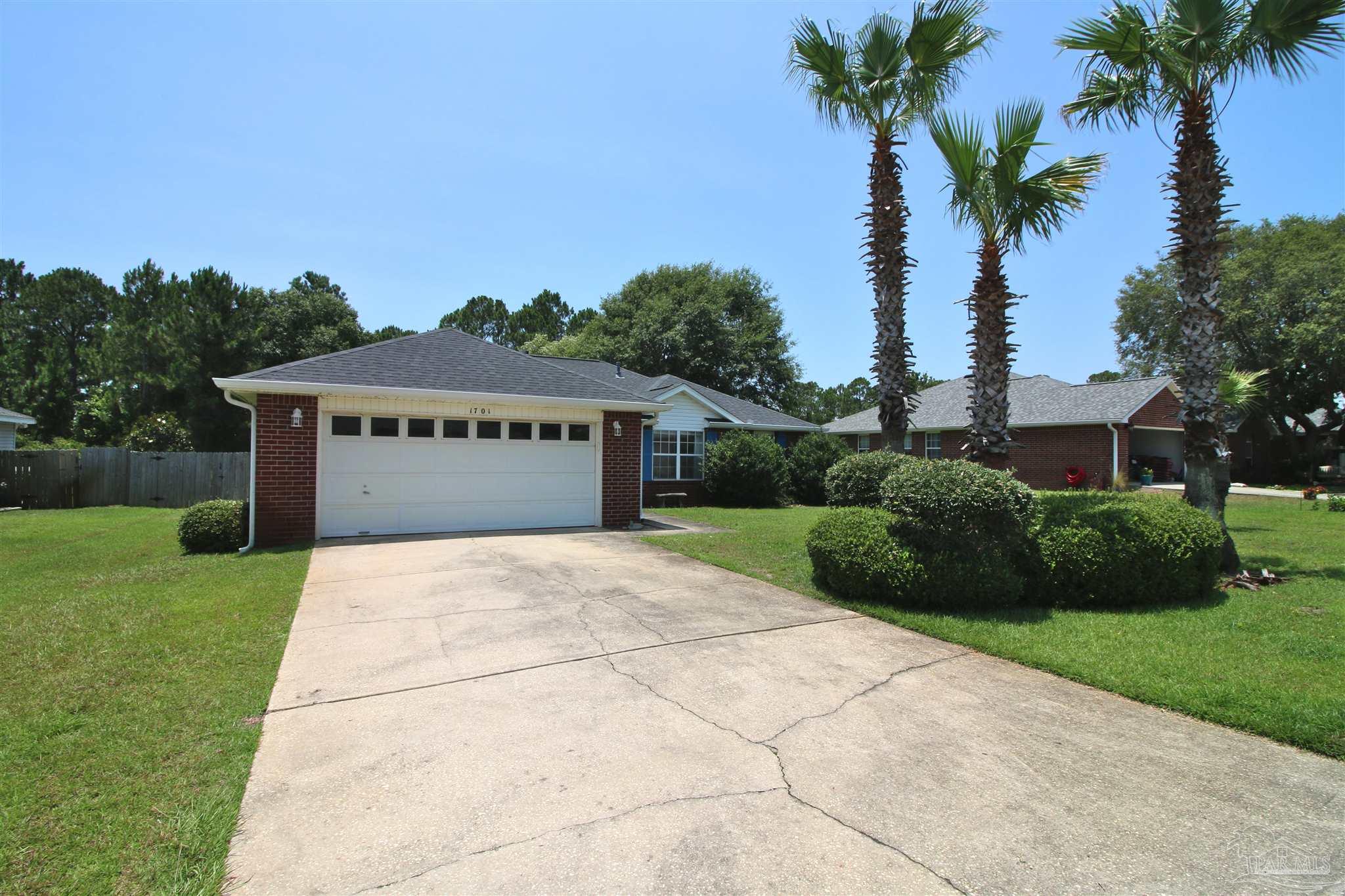 1701 Lighthouse Pointe Drive Gulf Breeze, FL 32563 - Photo 4 of 48 a front view of a house with a yard and garage
