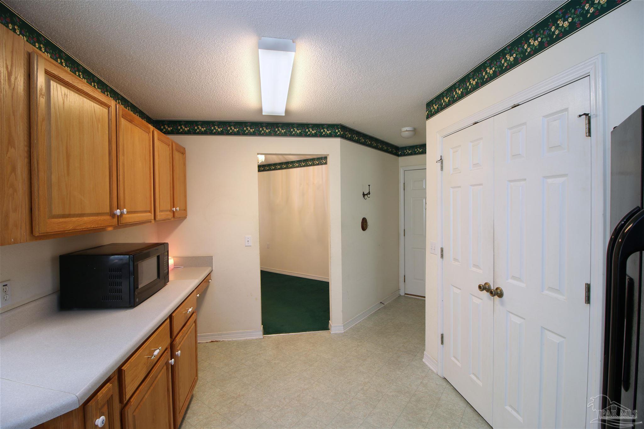 1701 Lighthouse Pointe Drive Gulf Breeze, FL 32563 - Photo 8 of 48 a kitchen with stainless steel appliances a refrigerator and cabinets