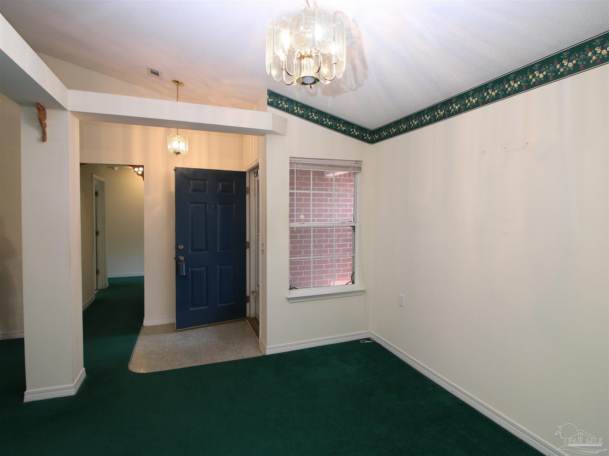 1701 Lighthouse Pointe Drive Gulf Breeze, FL 32563 - Photo 10 of 48 a view of an empty room with a fireplace and a window
