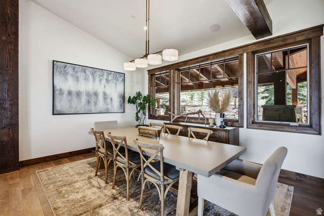 7885 North Rabbitbrush Court, Unit 13 Park City, UT 84098 - Photo 20 of 88 Dining space featuring wood-finish flooring, a linear chandelier, white walls, and wood-framed windows