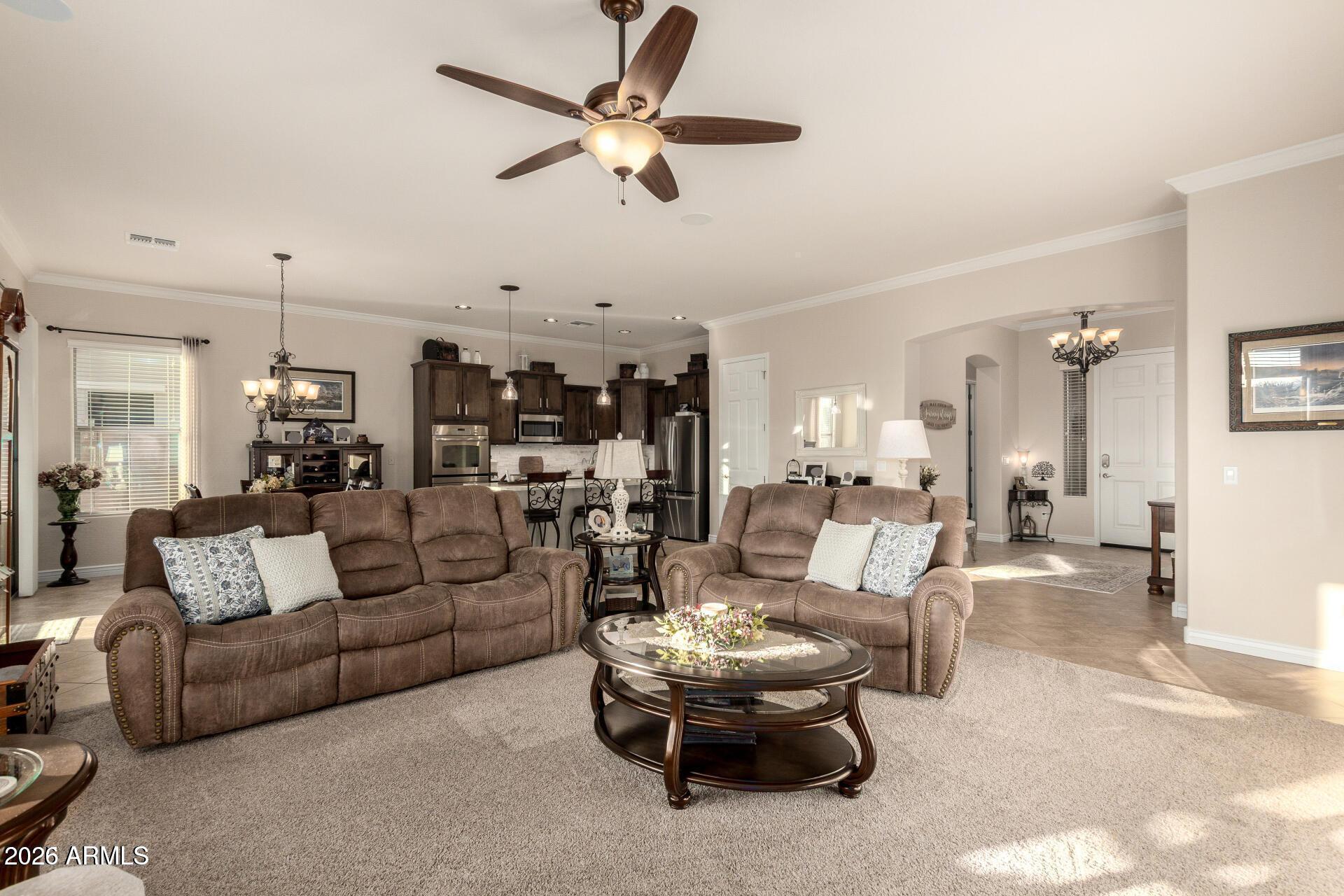 17869 West Verdin Road Goodyear, AZ 85338 - Photo 12 of 39 a living room with furniture kitchen view and a chandelier