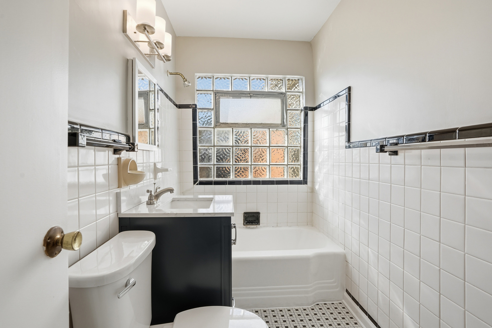 6550 North Ridge Boulevard, Unit 2 Chicago, IL 60626 - Photo 16 of 32 a bathroom with a sink a toilet a mirror a window and shower