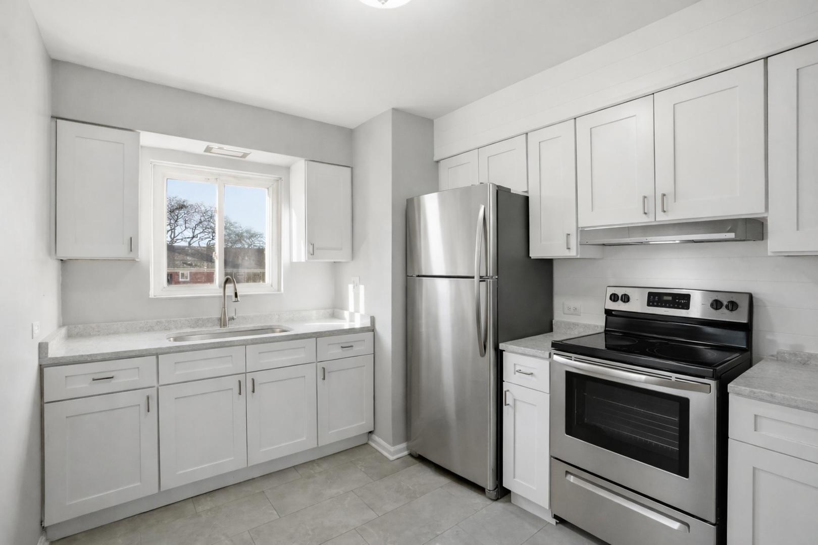 6550 North Ridge Boulevard, Unit 2 Chicago, IL 60626 - Photo 3 of 32 a kitchen with white cabinets and stainless steel appliances