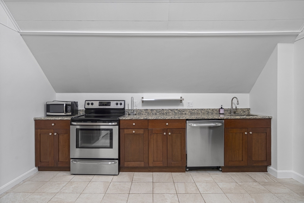 155 5th Street, Unit 3 Cambridge, MA 02141 - Photo 3 of 9 a kitchen with stainless steel appliances granite countertop a stove a sink and a refrigerator
