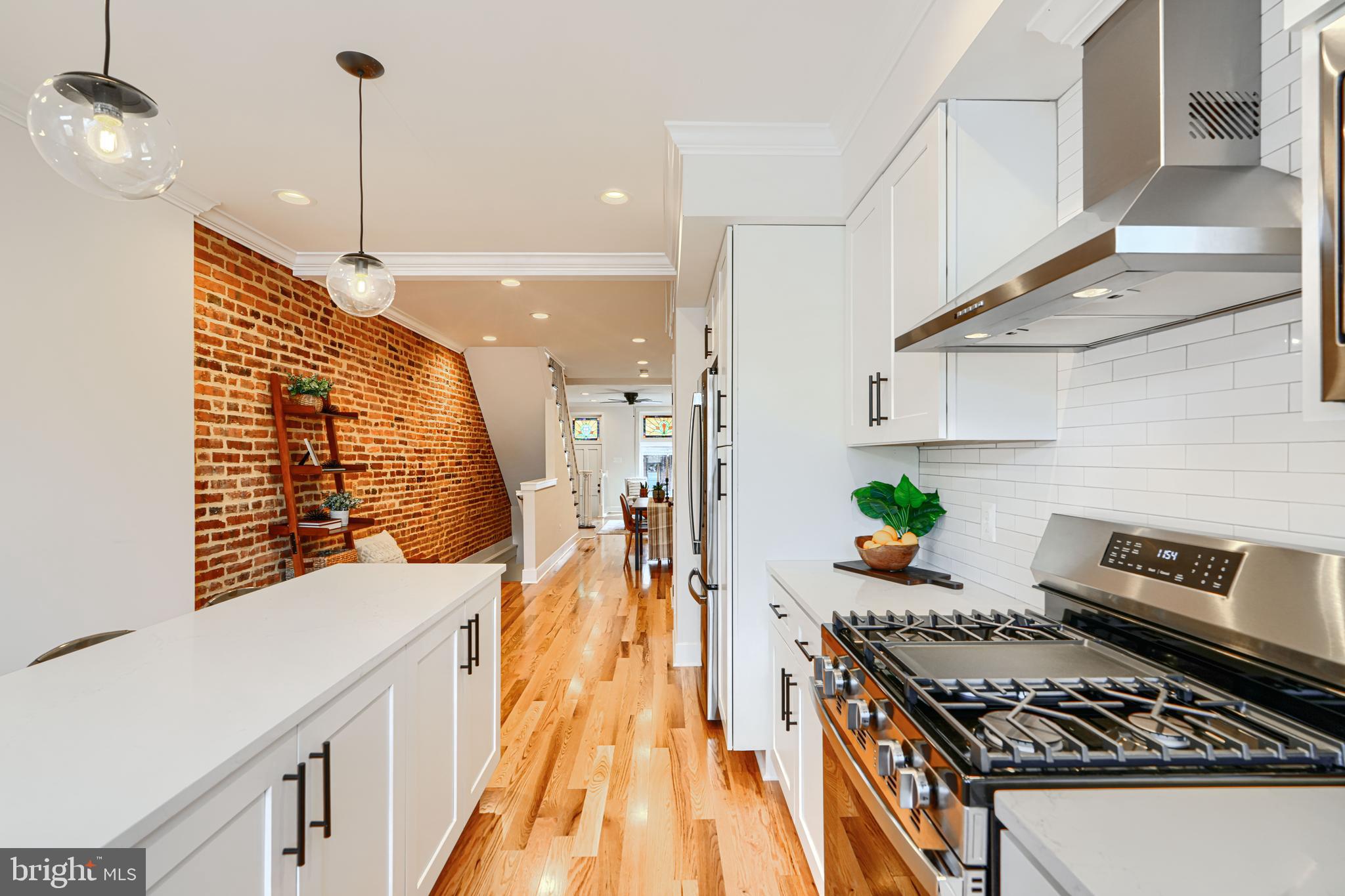 814 Grundy Street Baltimore, MD 21224 - Photo 11 of 31 a kitchen with stainless steel appliances granite countertop a stove and a wooden floors