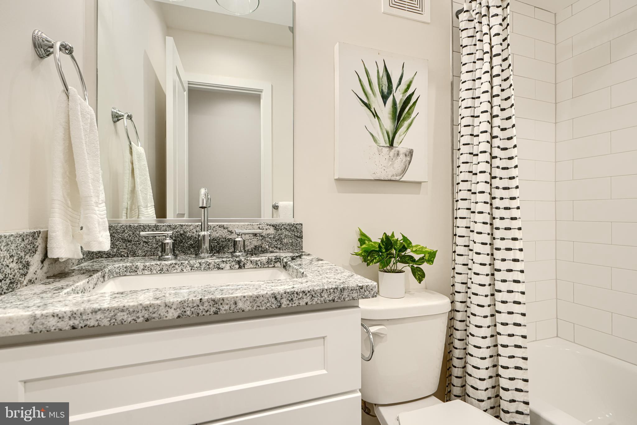 814 Grundy Street Baltimore, MD 21224 - Photo 17 of 31 a bathroom with a granite countertop sink a toilet and a mirror