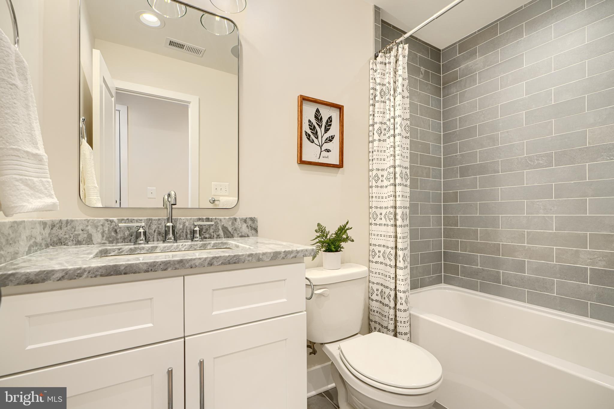 814 Grundy Street Baltimore, MD 21224 - Photo 21 of 31 a bathroom with a granite countertop toilet a sink and bathtub