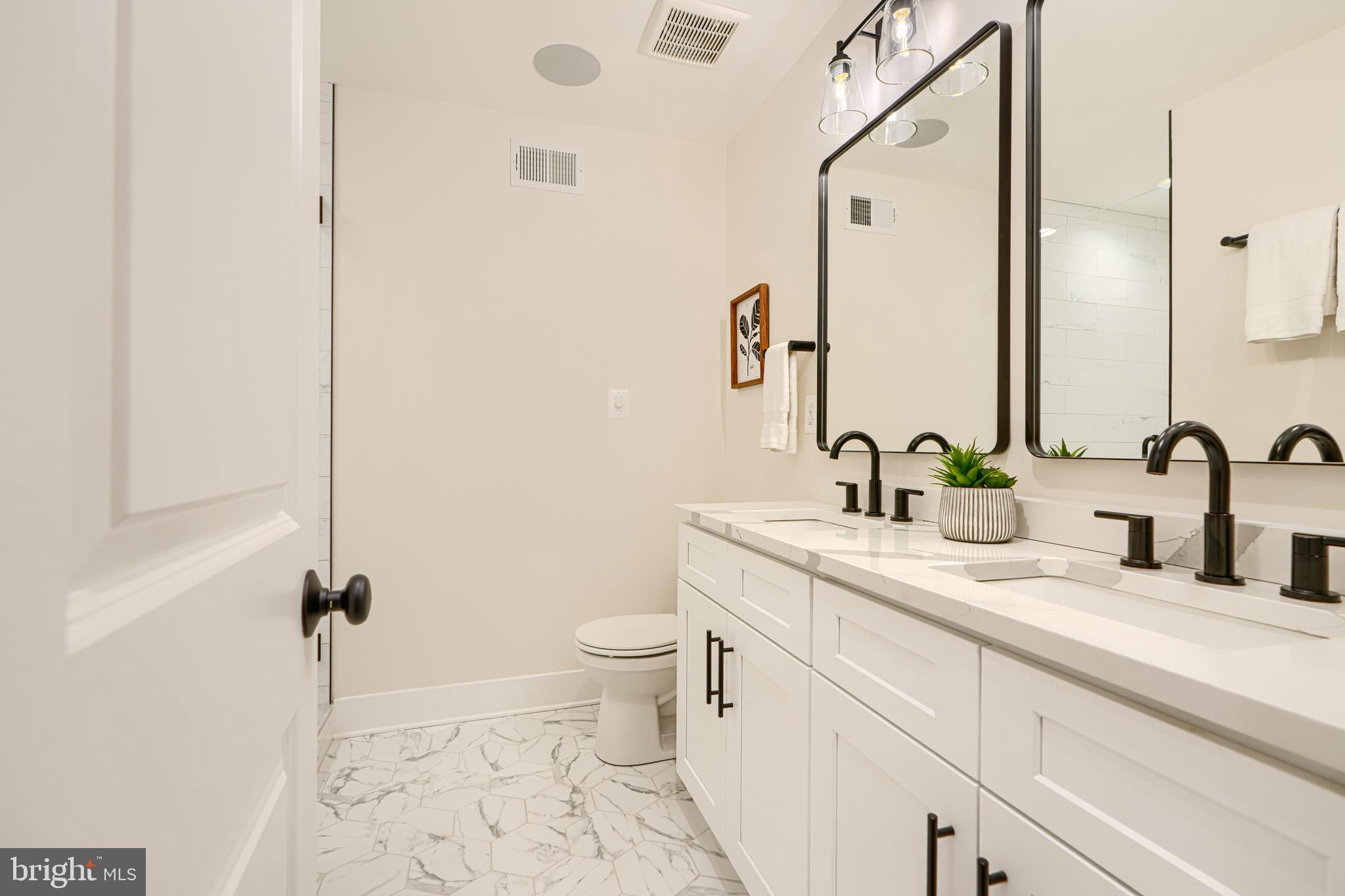 814 Grundy Street Baltimore, MD 21224 - Photo 27 of 31 a bathroom with a granite countertop sink a toilet and a mirror