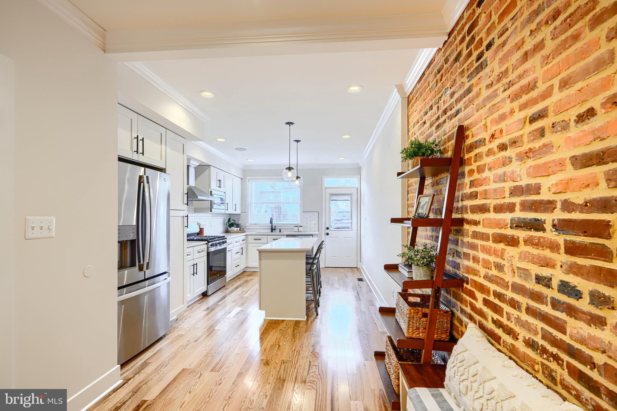 814 Grundy Street Baltimore, MD 21224 - Photo 9 of 31 a kitchen with stainless steel appliances a refrigerator a sink dishwasher a stove and white cabinets with wooden floor