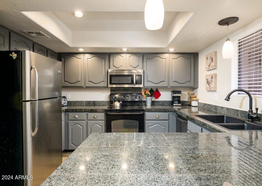 4303 East Cactus Road, Unit 235 Phoenix, AZ 85032 - Photo 11 of 29 a kitchen with stainless steel appliances granite countertop a refrigerator stove microwave and sink