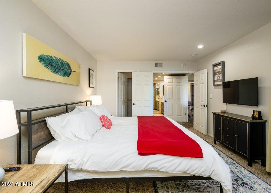 4303 East Cactus Road, Unit 235 Phoenix, AZ 85032 - Photo 21 of 29 a bedroom with a bed and a flat screen tv