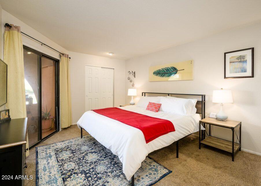 4303 East Cactus Road, Unit 235 Phoenix, AZ 85032 - Photo 22 of 29 a bedroom with a bed a rug and a dresser