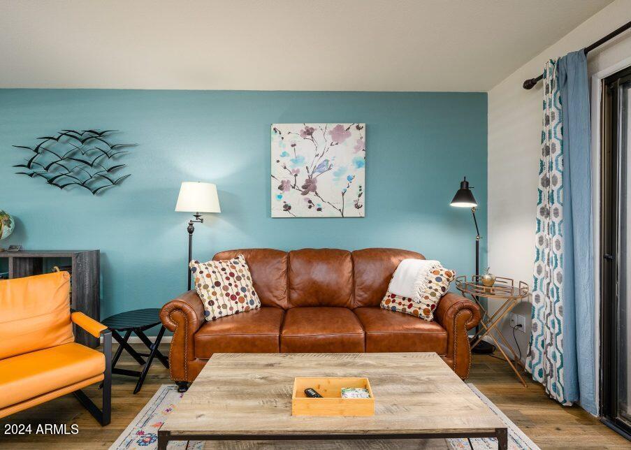 4303 East Cactus Road, Unit 235 Phoenix, AZ 85032 - Photo 3 of 29 a blue couch sitting in a living room with a rug