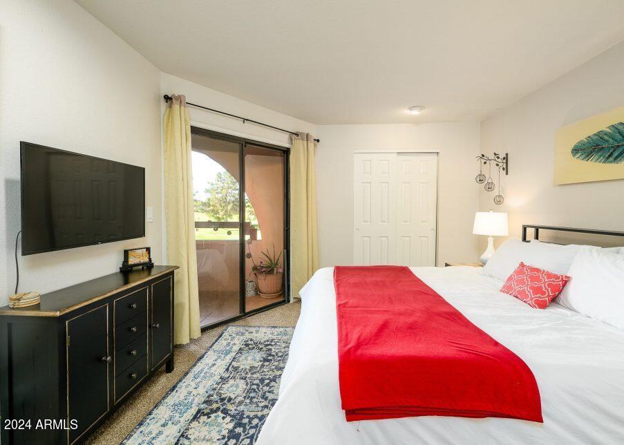 4303 East Cactus Road, Unit 235 Phoenix, AZ 85032 - Photo 6 of 29 a bedroom with a bed and a flat screen tv