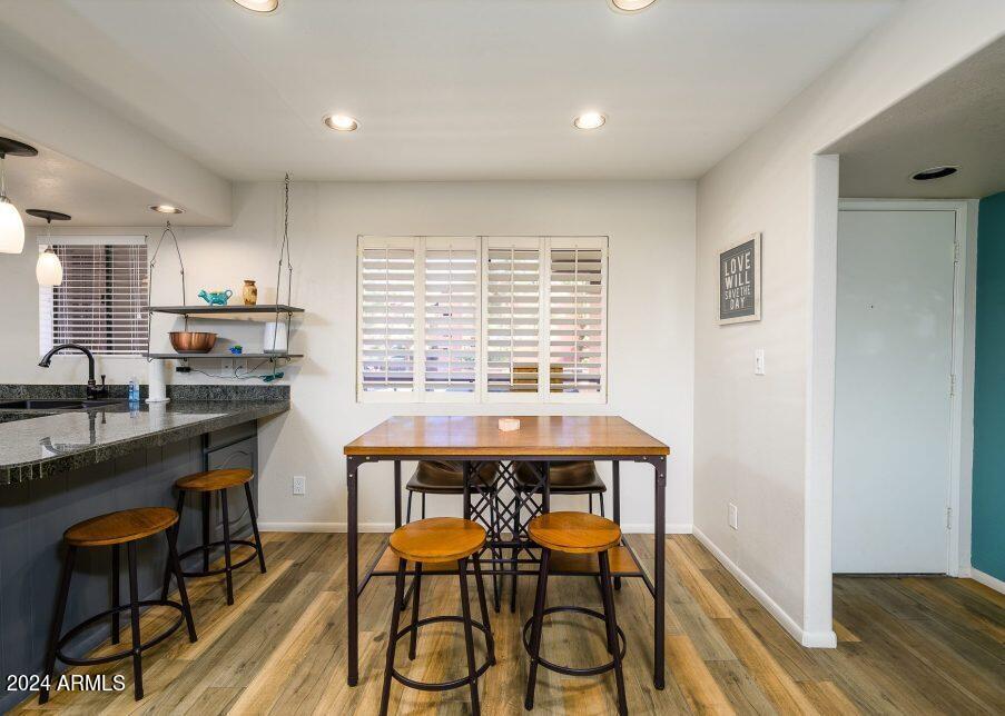 4303 East Cactus Road, Unit 235 Phoenix, AZ 85032 - Photo 9 of 29 a kitchen with stainless steel appliances a table and chairs in it