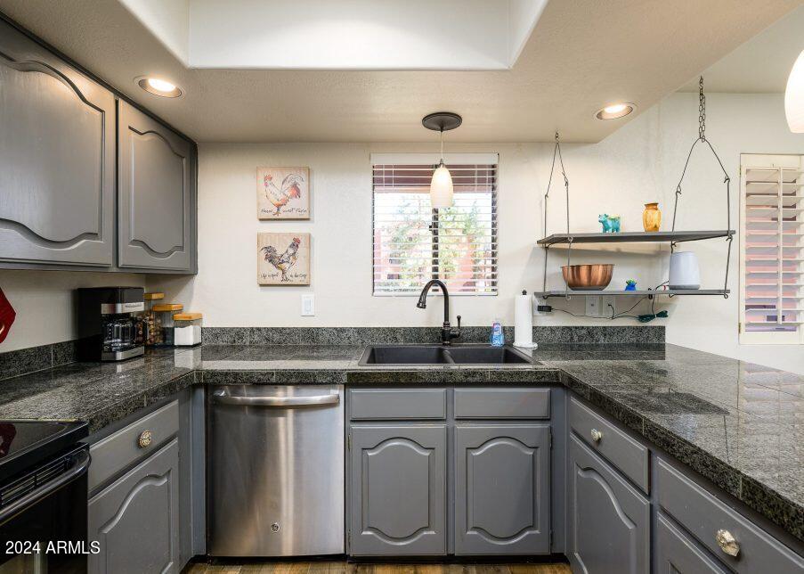4303 East Cactus Road, Unit 235 Phoenix, AZ 85032 - Photo 10 of 29 a kitchen with stainless steel appliances granite countertop a sink a stove and cabinets