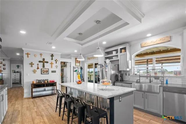a kitchen with stainless steel appliances kitchen island granite countertop a table chairs and a refrigerator