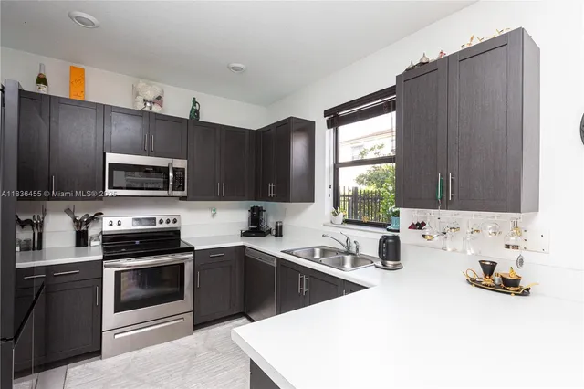 a kitchen with a sink a stove and cabinets