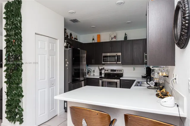 a kitchen with stainless steel appliances a stove refrigerator sink and cabinets