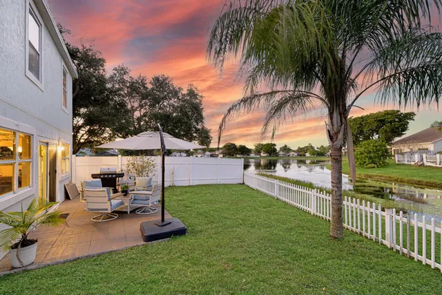 a view of a backyard with swimming pool and sitting area