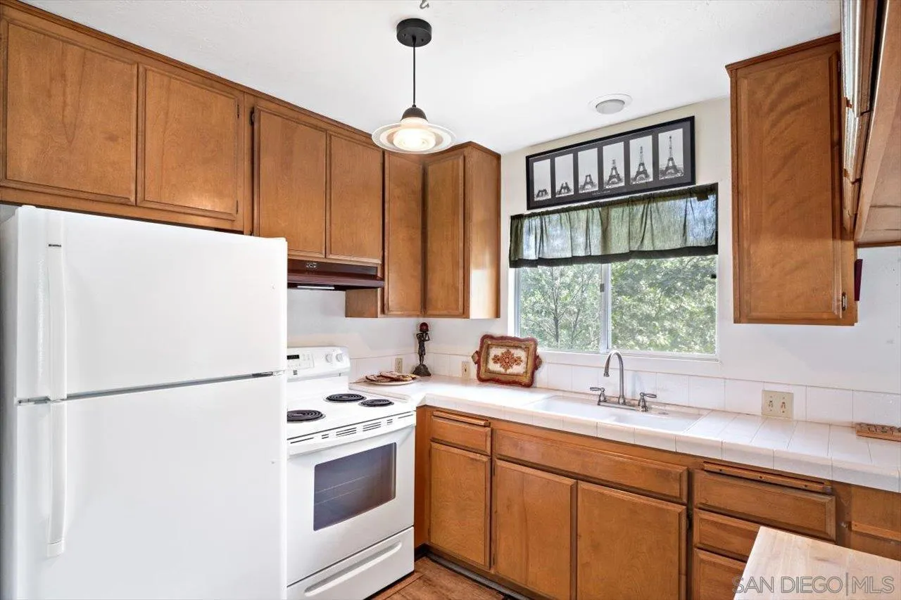 808 Pine Cone Drive Julian, CA 92036 - Photo 13 of 23 a kitchen with stainless steel appliances a refrigerator sink and cabinets